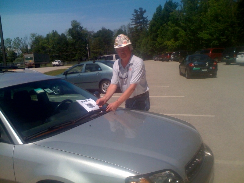Man placing leaflets on cars in parking lots